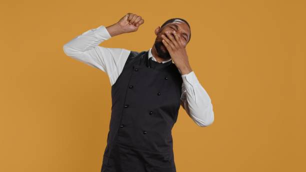 istock Tired waiter yawning and stretching after a night shift and feeling exhausted 2178507614
