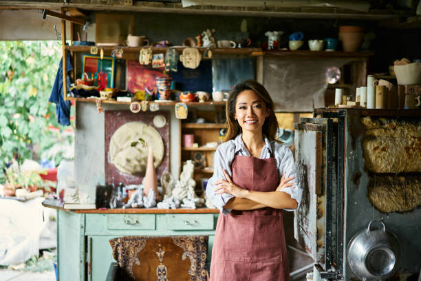 istock Pretty female artist smiling and posing at creative workshop with her artwork in the background. 2178507795