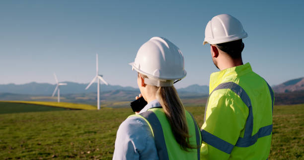 istock Engineer, teamwork and people on wind farm for renewable energy with radio communication for turbine performance. Technician back, supervisor and inspection for windmill maintenance or sustainability 2178507796