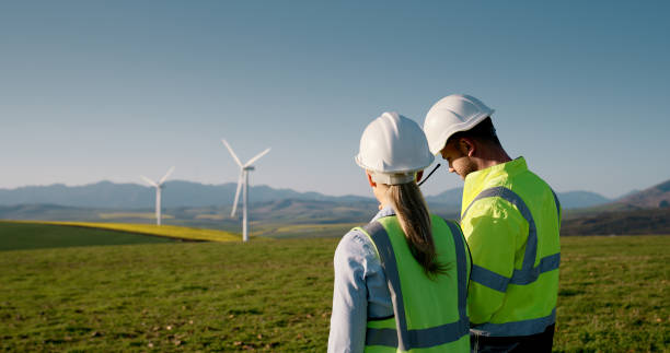 istock Business people, electrical engineers and wind turbine with clean energy, renewable generation or reproduction system. Back view, man and woman with eco friendly resources for alternative power 2178507830
