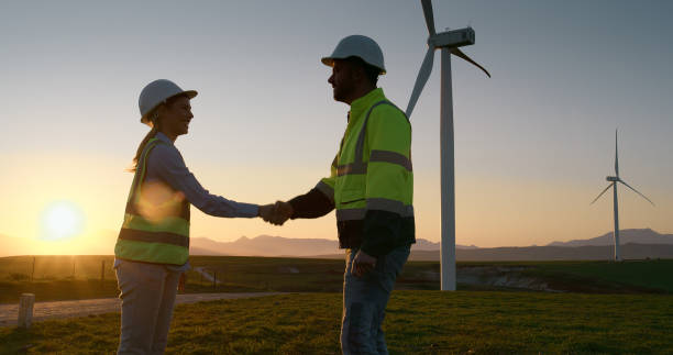 istock Business people, engineer and handshake with sunset for renewable energy or eco friendly power in nature. Businessman, woman or contractors shaking hands for alternative resources or production 2178507884