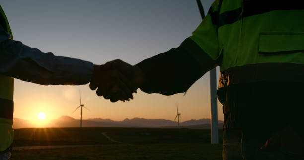 istock Closeup, engineer and handshake with sunset for clean energy or eco friendly power in nature. Business people, colleagues or contractors shaking hands for agreement, renewable project or production 2178507885