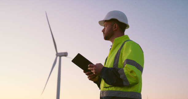 istock Engineer, man and tablet with windmill outdoor for generator maintenance, inspection and electricity safety. Male person, digital and sustainable for renewable energy, power project and wind turbine 2178507933