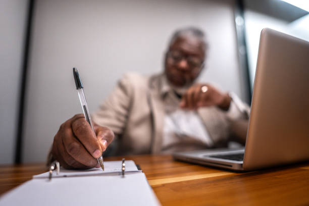 istock Close-up of a man annotating on note pad at office 2178507960