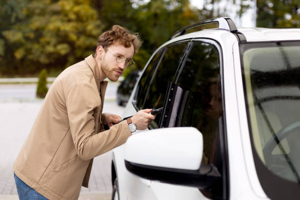 istock Man cleaning car window with squeegee after washing 2178511367