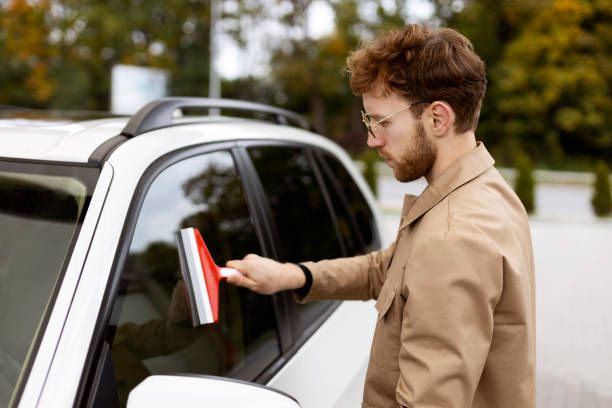 istock Young stylish man cleaning car window with squeegee 2178511415