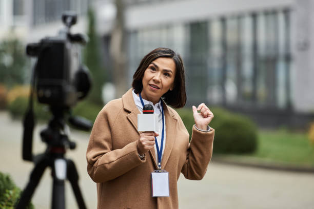 istock A journalist in a brown coat reports news outdoors on a sunny day 2178511496