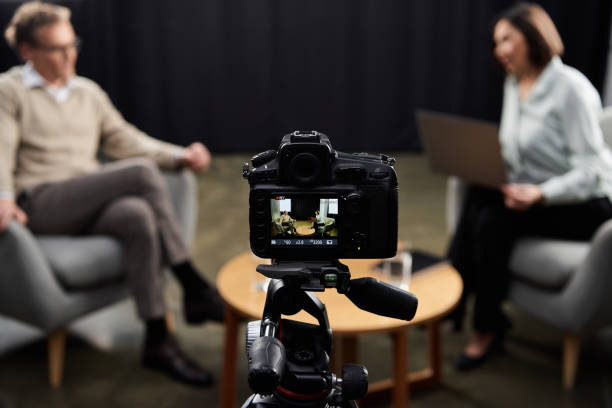 istock Engaging journalist hosts a thoughtful podcast interview with a guest in the studio 2178511716