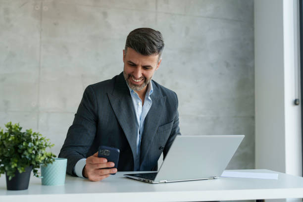 istock Smiling Businessman Engaging with Technology in Office 2178513128
