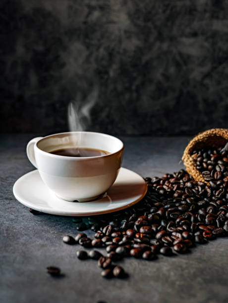 istock Americano coffee cup and roasted coffee beans falling in a burlap sackon gray background, Black coffee cup aromatic 2178517621