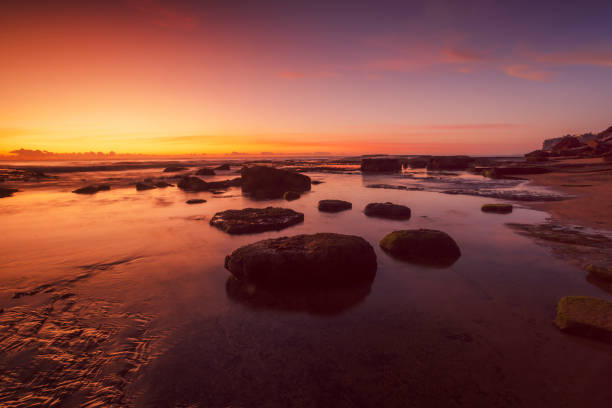 istock Sunrise over the rocky reef sky reflecting in shallow water 2178520713