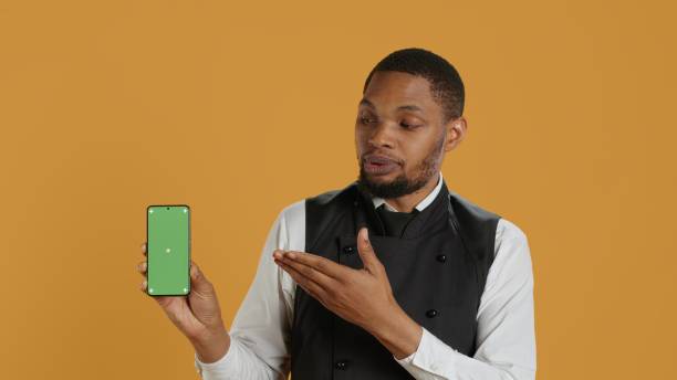 Restaurant staff showing a smartphone with green screen in studio,