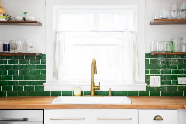 istock A gold kitchen faucet with a green subway tile backsplash. 2178524465