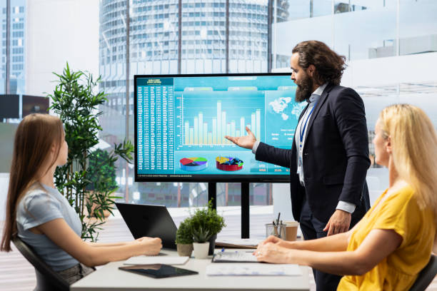 istock Financial adviser presents market analytics to clients using large screen 2178528690