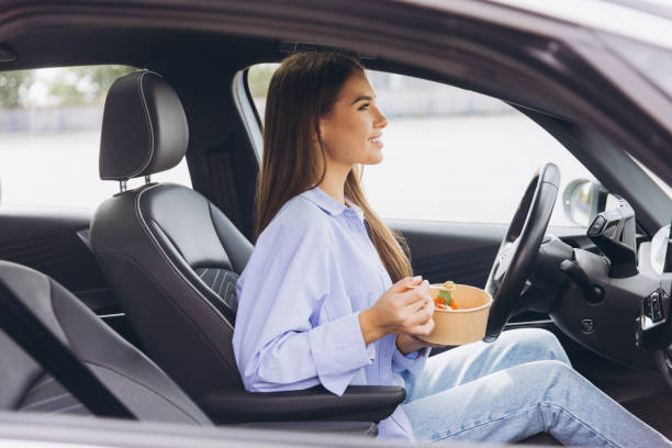 istock Woman Enjoying a Healthy Meal Inside Her Car While Parked, Emphasizing Convenience and Modern Lifestyle Choices for Busy Individuals On the Go 2178531957