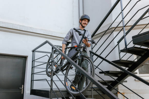 istock Mid adult man carrying a bicycle down the stairs 2178532075