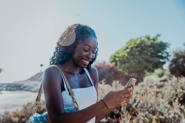istock A woman is smiling while looking at her cell phone and writing a message 2178532114