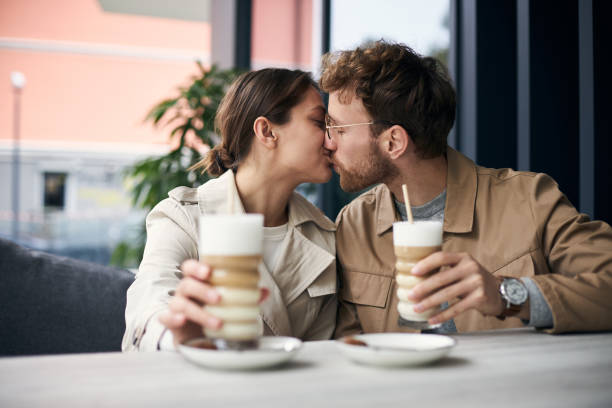 istock Young couple kissing while having coffee at the cafe 2178532143