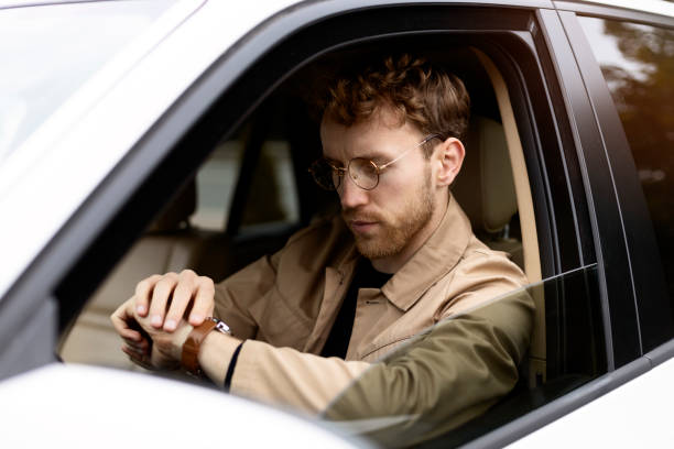istock Businessman checking time while driving in car 2178532153