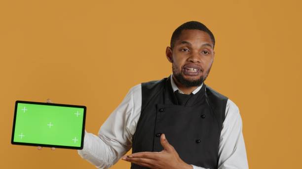 istock Catering employee presenting isolated chroma key display while he wears an apron 2178532733