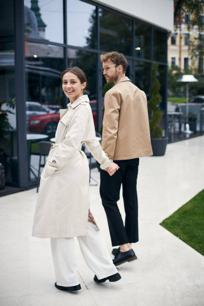 istock Happy couple holding hands is walking down the street 2178532878