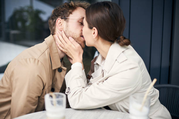 istock Young couple kissing at cafe table on a date 2178533235