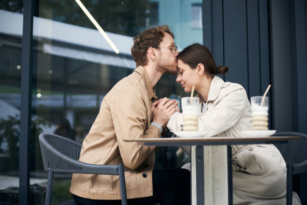 istock Young man kissing woman on forehead at cafe table 2178533250