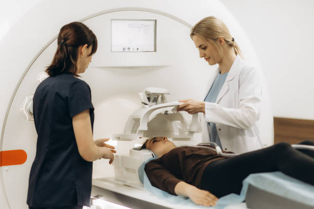 Doctors preparing patient for full body scanning procedure inside MRI diagnostic center.