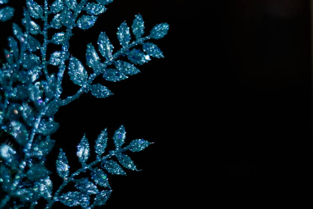 Blue christmas ornament glittering on dark background with bokeh effect