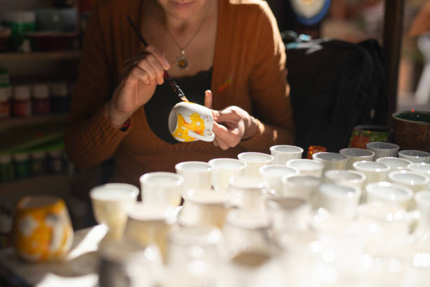 istock Female potter coloring handmade ceramic cup using brush and color. 2178536728