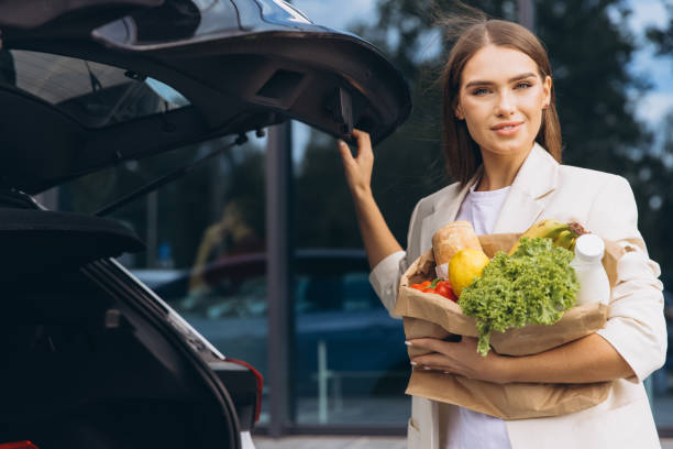 istock Woman Loading Groceries Into Car Trunk After Shopping 2178536887