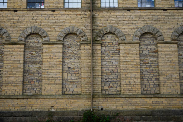 windows in an old building filled in by traditional bricks giving a wall with interesting features