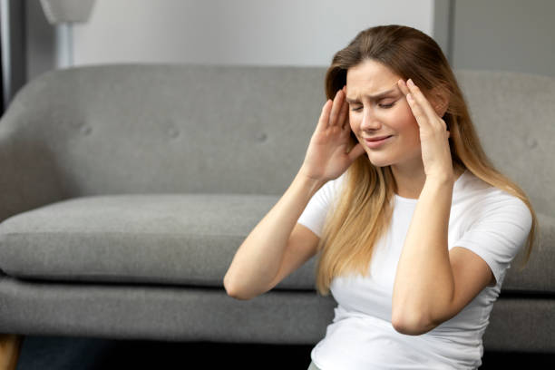 istock Young woman suffering from a strong headache at home 2178537728