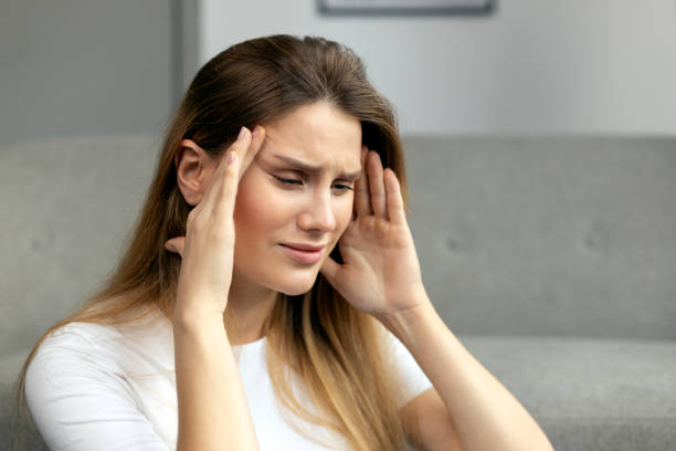 istock Young woman suffering from a strong headache at home 2178537752