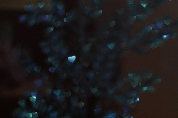 Blue christmas ornament glittering on dark background with bokeh effect