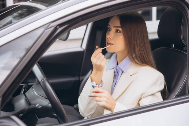 istock Woman Applying Lipstick While Sitting in a Car 2178540688