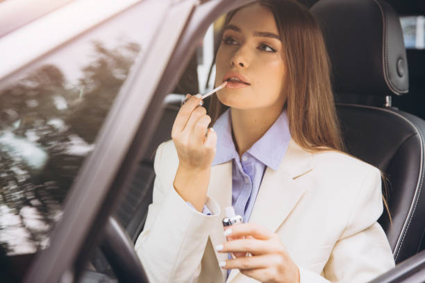 istock Businesswoman Applying Lip Gloss Inside Her Car 2178540834