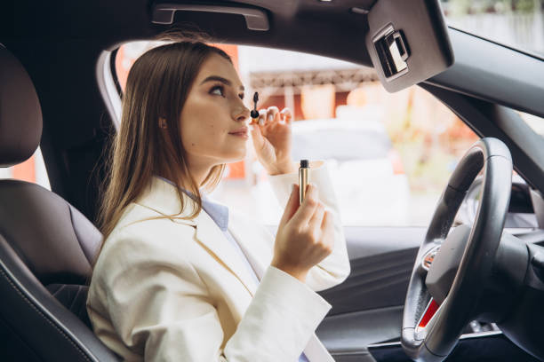 Young Woman Applying Makeup While Sitting in a Car