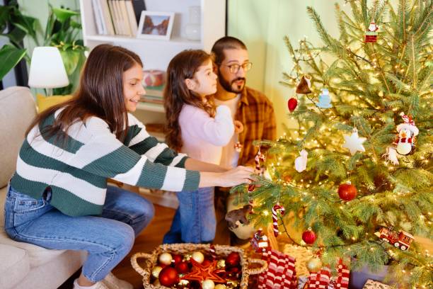 istock Cute little girl decorating Christmas tree with her parents 2178541049