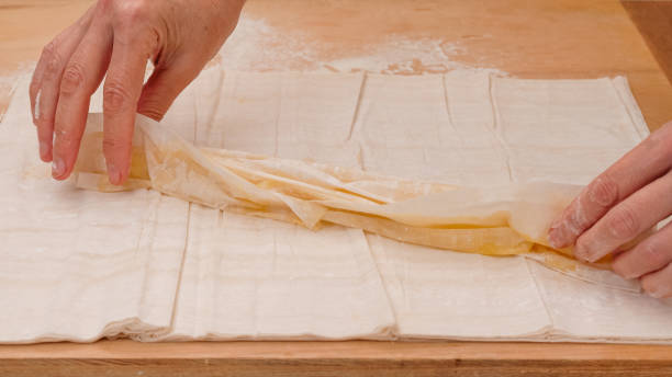 istock Chef folding buttered layers of phyllo dough into rolls 2178548525