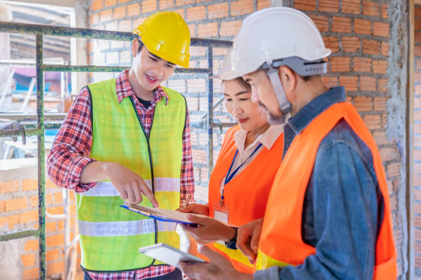 istock a young foreman explaining project progress to team experienced inspector of real estate home project while having inspection on site work 2178548528