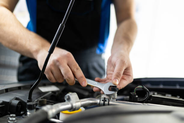istock A mechanic repairs a car engine using a wrench in a well-lit garage during the afternoon 2178551288