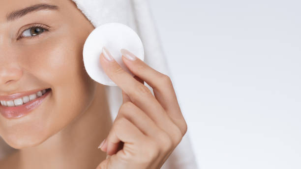 istock Smiling Woman Cleansing Face With Cotton Pad in Skincare Routine 2178551377