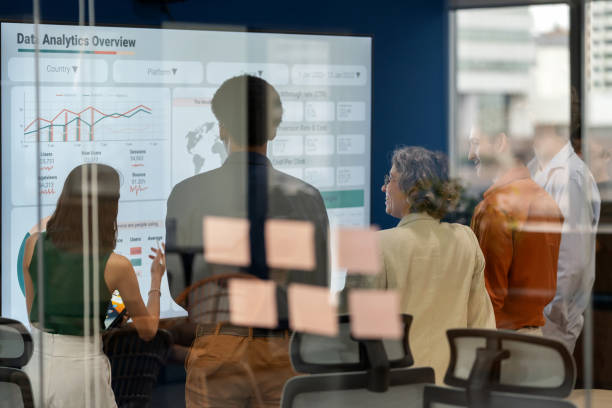 Diverse business development team brainstorming new products and services using a digital display during a business meeting. Business Intelligence and data-driven decisions empowering strategy, growth, and resilience in a modern office.