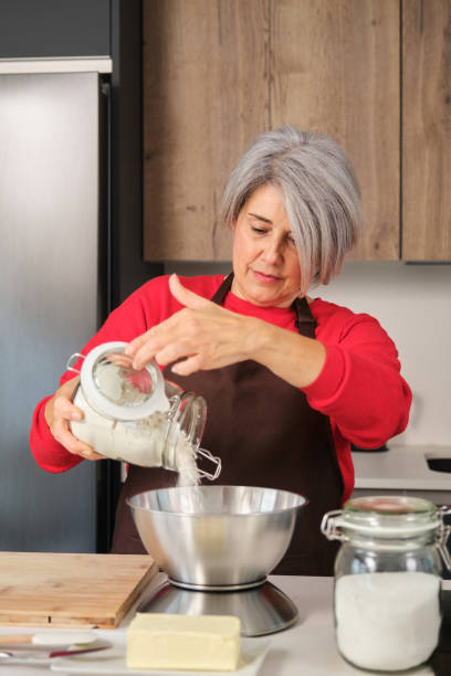 istock Woman adding flour while baking Christmas cookies in her kitchen 2178552236