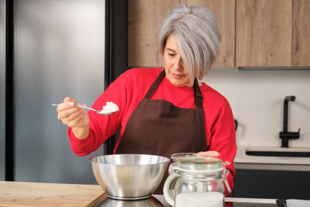 istock Senior woman adding flour while baking Christmas cookies in her kitchen 2178552285