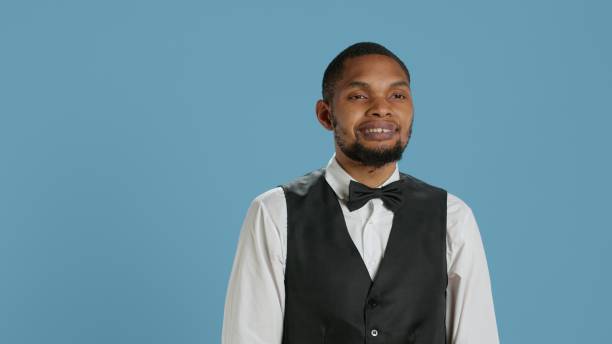 istock Friendly bellman porter with suit and tie waving at hotel guests 2178554280