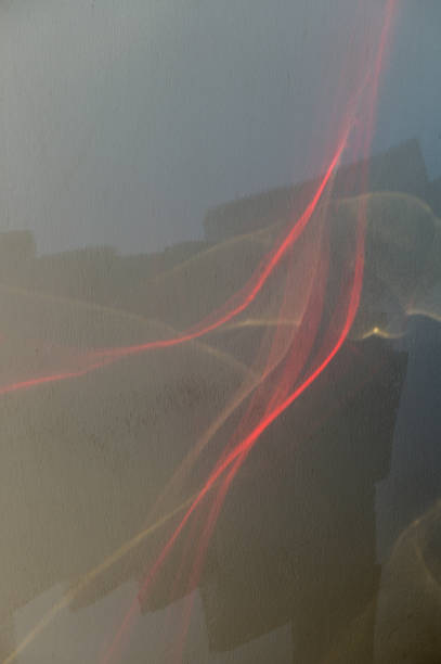 istock Abstract Play of Light and Shadows on a Reflective Surface, Highlighting Vibrant Red Streaks Against a Muted Backdrop During Daytime 2178559246