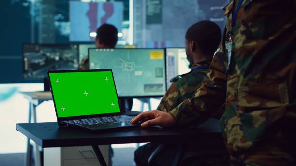 istock Army officer studies isolated greenscreen display on a laptop in control room 2178560706