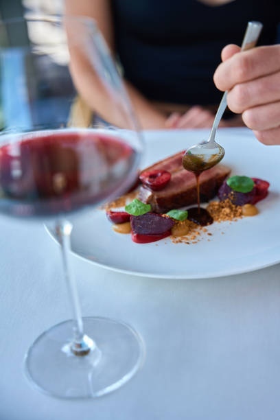 istock Waiter covering meat with sauce on a white plate for lady 2178561893